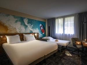 Cette chambre comprend 2 lits et une carte murale. dans l'établissement Novotel Antibes Sophia Antipolis, à Valbonne 132 autres photos