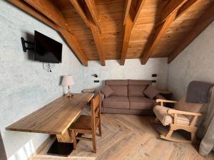a living room with a wooden table and a couch at Vivienda Turistica Cueto Larama VUT-LE-860 in Villafeliz