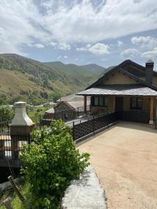 a house with a large patio with mountains in the background at Vivienda Turistica Cueto Larama VUT-LE-860 in Villafeliz