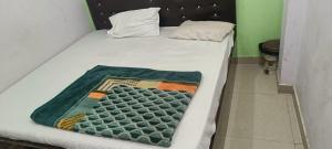 a bed with a blanket on top of it at Hotel V L in Lucknow
