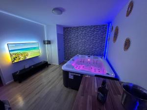 Un televizor și/sau centru de divertisment la Priv8Spa New Love Room Jacuzzi Privée