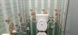 a bathroom with a toilet with flowers on the wall at Hotel V L in Lucknow