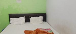 a bedroom with a bed with white sheets and pillows at Hotel V L in Lucknow +13 photos