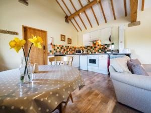 a living room with a table with a vase of yellow flowers at 1 Bed in Ashford in the Water PK574 in Great Longstone