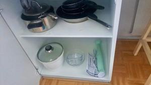 a white shelf with dishes and utensils on it at Interesting Kemi Apartment with peaceful environment free parking in Kemi +2 photos