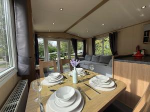 a table with plates and dishes on it in a caravan at Sunningdale comfy suite in Tattershall