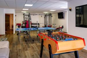 a room with a foosball table and gym equipment at La Villa Perchée, Appartements Élégants, sauna Privé, sport, terrasses et Vue Panoramique, Parking protégé, proche PARIS in Saint-Prix