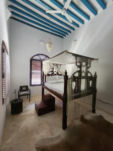 a bedroom with a canopy bed and a ceiling at Baytulkher in Lamu +27 photos