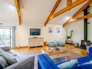 a living room with a blue couch and a tv at 3 bed in South Molton HILRO in Mariansleigh