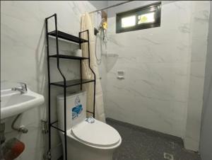 a white bathroom with a toilet and a sink at Aga's Transient House in Baguio +6 photos
