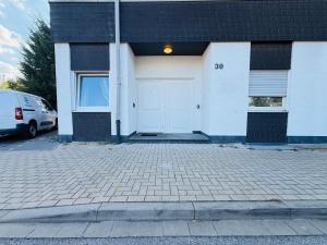 a building with a white door and a parking lot at Emilbnb in der Monheimer Straße in Monheim