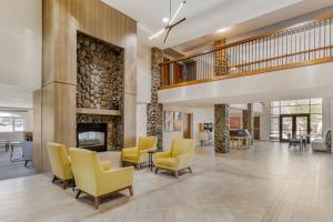 a lobby with yellow chairs and a fireplace at Holiday Inn Express Fallon by IHG in Fallon