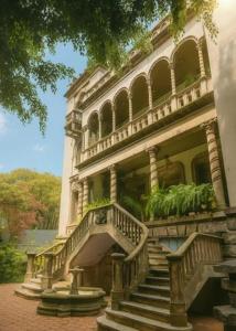 a large building with stairs and plants on it at Maison Lezard in Mexico City