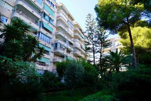 un gran edificio de apartamentos con árboles delante de él en Apartamento Parque 2 Playa de Gandía, en Playa de Gandía