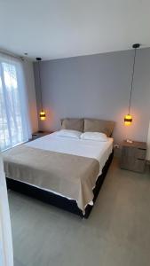 a bedroom with a large bed with two lights on it at Luxury Suite del Faro, Romance en la represa in Prado