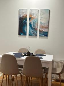 comedor con mesa y 4 pinturas en la pared en Apartman Radmanović, en Banja Luka 16 fotos más