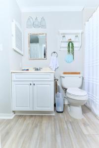 a white bathroom with a toilet and a sink at Summer Breeze D212 - Bungalow 6 in Destin