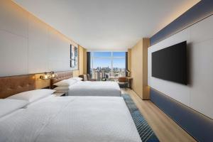 a hotel room with two beds and a flat screen tv at Four Points by Sheraton Beijing Sanlitun Workers Stadium in Beijing