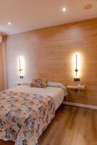 a bedroom with a bed and two lights on the wall at La Siesta in Villamarciel