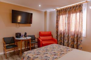 a room with a bed and a chair and a table at La Siesta in Villamarciel