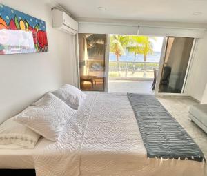 a large bed in a bedroom with a view of the ocean at Aptos Sunrise Beach in San Andrés