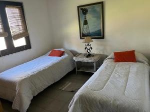 a bedroom with two beds and a table with a lamp at La Angelita Oeste in San Andrés de Giles