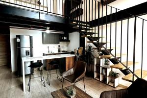 Central Medellin Modern Loft - Balcony and Transit في ميديلين: مطبخ به درج يؤدي الى دور علوي