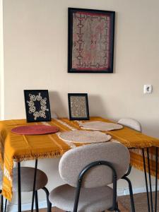 a dining room table with chairs and a picture on the wall at Apartment in Prishtina, Kosovo in Pristina +4 photos