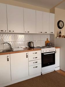 a kitchen with white cabinets and a stove top oven at Apartment in Prishtina, Kosovo in Pristina