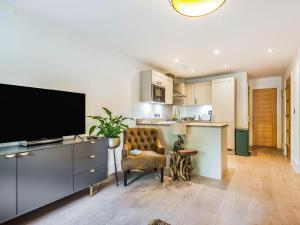 a living room with a television and a kitchen at 1 Bed in Brockenhurst 87525 in Brockenhurst