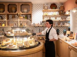 a woman standing in a kitchen preparing food at Novotel Nice Aéroport Cap 3000 in Saint-Laurent-du-Var +79 photos