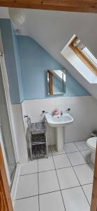 a bathroom with a sink and a mirror at Charming Coastal Cottages by Portsalon Beach in Portsalon +32 photos