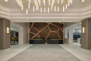 a lobby with a reception desk and a chandelier at Denver Airport Marriott at Gateway Park in Aurora