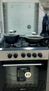 two frying pans sitting on top of a stove at City Center Apartment "Afsona mall" in Irvadan