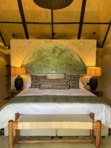a bedroom with a large bed with a green headboard at O'Leleshwa Retreat in Naivasha