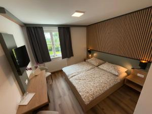 a small bedroom with a bed and a television at Groß Genuss in Kaibing