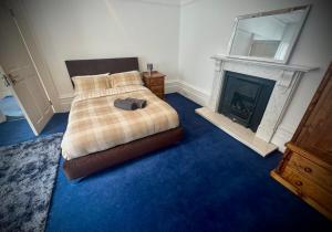 une chambre avec un lit et une cheminée dans l'établissement Spacious Rooms Edgbaston Central WiFi Parking, à Birmingham