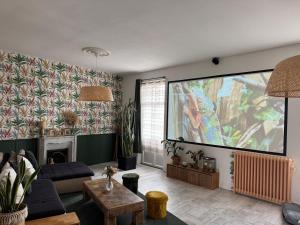 a living room with a large screen in the wall at Maison Marély in Chantonnay
