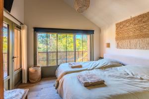 ein Schlafzimmer mit zwei Betten und einem großen Fenster in der Unterkunft New luxury villa, outbuilding in Lacanau
