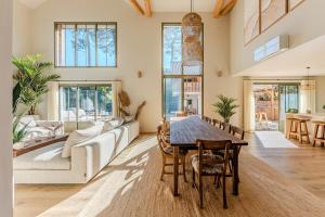ein Wohnzimmer mit einem Tisch und einem Sofa in der Unterkunft New luxury villa, outbuilding in Lacanau
