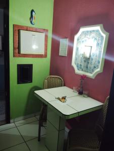 un tavolo in una stanza con pareti verdi e rosa di Pousada Devaneios ad Ananindeua