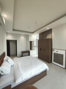 sypialnia z dużym białym łóżkiem i kominkiem w obiekcie Muscat City Stay - 2BR Apt 308 near Grand & Avenue Mall w mieście Ghukra