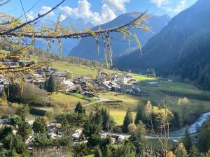 a village in a valley with a river and mountains at La casetta di Piera in Brusson +3 photos
