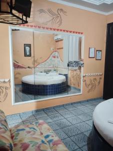 un grande specchio in una stanza con un letto e un lavandino di Pousada Devaneios ad Ananindeua