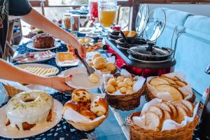 einen Tisch mit Körben mit Brot und Gebäck in der Unterkunft VELINN Pousada 8 Ilhas in Ilhabela + 51 Fotos