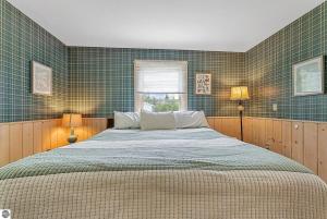 a bedroom with a large bed with green tiled walls at Cozy A Frame Waterfront Chalet Dock Fireplace in Traverse City