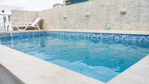 バランキージャにあるHotel Oxford Barranquillaの隣のスイミングプール(椅子付)