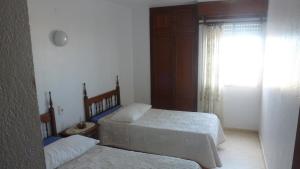 a bedroom with two beds and a window at Primera línea Playa Gandia in Gandía