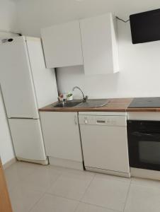 a small kitchen with white appliances and a sink at Apartamentos calatorao in Calatorao