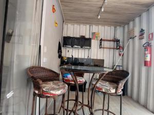 a table and two bar stools in a trailer at Chalé na lata in Pirenópolis